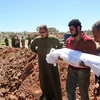 Chôn cất nạn nhân thiệt mạng sau một vụ tấn công bằng khí độc ở Syria. (Nguồn: AFP) 