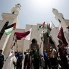 Người dân Palestine phất cờ ủng hộ Qatar sau khi nước này bị nhiều quốc gia cắt quan hệ ngoại giao. (Nguồn: AFP)