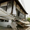 Ngôi nhà đổ sập vào một chiếc ô tô tại thành phố Mashiki sau trận động đất hôm 14/4. (Ảnh: Reuters)
