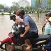 Xe cải tiến chở xe máy thoát khỏi khu vực ngập lụt quanh Keangnam có giá 50.000 đồng/xe. (Ảnh: PV/Vietnam+)
