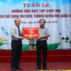 Thứ trưởng Nguyễn Vinh Hiển trao tặng 800 quyển sách cho Trường Trung học cơ sở Quỳnh Hồng, thị trấn Quỳnh Côi, huyện Quỳnh Phụ. (Ảnh: Quý Trung/TTXVN)