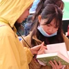 Dù trời mưa rét nhưng vẫn khá đông bạn trẻ đến tham gia chương trình để đổi và chọn mua sách. (Ảnh: PV/Vietnam+)