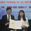 Phó hiệu trưởng Hoàng Anh Tuấn trao quyết định mở chương trình đào tạo chất lượng cao xã hội hóa ngành Báo chí cho Viện trưởng Viện Báo chí và Truyền thông Đặng Thị Thu Hương. (Ảnh: PV/Vietnam+)
