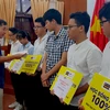Tiến sỹ Lê Trường Tùng, Chủ tịch Hội đồng quản trị Trường Đại học FPT, trao học bổng cho các học sinh. (Ảnh: PV/Vietnam+)
