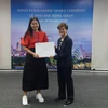 Đại sứ Singapore, bà Catherine Wong trao học bổng cho học sinh. (Ảnh: Phạm Mai/Vietnam+)