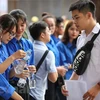 Sinh viên tình nguyện hỗ trợ thí sinh trong kỳ thi Trung học phổ thông quốc gia. (Ảnh: PV/Vietnam+)