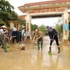 Lực lượng quân đội phối hợp cùng các giáo viên trường Tiểu học số 1 thị trấn Kiến Giang tổng vệ sinh môi trường sau khi lũ rút. (Ảnh: Vũ Sinh/TTXVN)