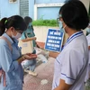Thí sinh rửa tay sát khuẩn trước khi vào điểm thi thi. (Ảnh: PV/Vietnam+)