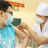 Nhân viên y tế quận Hà Đông tiêm vaccine phòng COVID-19 cho học sinh lớp 6 tại điểm tiêm chủng trường Trung học cơ sở Lê Quý Đôn. (Ảnh: Minh Quyết/TTXVN)