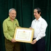 Bộ trưởng Bộ Giáo dục và Đào tạo Nguyễn Kim Sơn tặng bằng khen cho ông Nguyễn Huy Kỳ. (Ảnh: Bộ GD-ĐT)