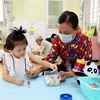 Giáo viên trường Mầm non Sơn Ca 14, quận Phú Nhuận, Thành phố Hồ Chí Minh dạy trẻ nhận biết đồ vật. (Ảnh: Hồng Đạt/TTXVN)