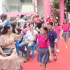 Những học sinh mới của Trường TH School bước vào trong tiếng chuông chào đón của các học sinh cũ và sự cổ vũ nồng nhiệt của các phụ huynh. (Ảnh: PM/Vietnam+)