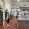 Nhân viên lau dọn khu vực bếp tại Trường Mẫu giáo số 3. (Ảnh: PV/Vietnam+)