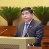 Bộ trưởng Bộ Kế hoạch và Đầu tư Nguyễn Chí Dũng thừa ủy quyền của Chính phủ trình bày tờ trình và tóm tắt dự thảo Nghị quyết. (Ảnh: Doãn Tấn/TTXVN)