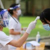 Nhân viên y tế học đường kiểm tra sức khỏe học sinh trong giai đoạn dịch COVID-19. (Ảnh: Minh Sơn/Vietnam+)