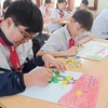 Học sinh vẽ tranh hưởng ứng cuộc thi. (Ảnh: Phạm Mai/Vietnam+)