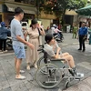 Thí sinh đi xe lăn đến điểm thi vì bị gãy chân. (Ảnh: NTCC)