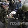 Đưa người bị thương ra ngoài trong cuộc đụng độ với cảnh sát sau khi những người biều tình chiếm được vị trí mới gần quảng trường Độc lập tại Kiev ngày 20/2. AFP-TTXVN
