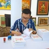 Bác sỹ Ngô Đức Hùng ký sách tại Hà Nội. (Ảnh: NVCC)