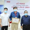 Ông Lê Xuân Thành, Trưởng Ban tổ chức Giải (trái) và nhà thơ Trần Đăng Khoa, Chủ tịch Hội đồng giám khảo (phải) trao giải cho tác giả Bình Ca (giữa). (Ảnh: Hòa Nguyễn/Vietnam+)