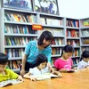 Các em học sinh chăm chú đọc sách tại thư viện Làng Sen. (Ảnh: Tá Chuyên/TTXVN)