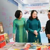 Phó Chủ tịch nước Võ Thị Ánh Xuân thăm gian trưng bày các ấn phẩm báo chí của Thông tấn xã Việt Nam. (Ảnh: TTXVN)