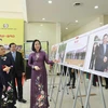 Tổng Giám đốc Thông tấn xã Việt Nam Vũ Việt Trang giới thiệu với đại biểu về ảnh trưng bày tại triển lãm. (Ảnh: Minh Quyết/TTXVN)