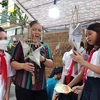 Bà Nguyễn Thị Tuyến ở Hoài Đức hướng dẫn các em thiếu nhi làm đèn ông sao. (Ảnh: Minh Thu/Vietnam+)