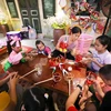 Các em nhỏ được tham gia làm đồ chơi truyền thống tại Hoàng thành Thăng Long. (Ảnh: Thanh Tùng/TTXVN)