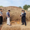 Phó giáo sư-tiến sỹ Tống Trung Tín, Chủ tịch Hội Khảo cổ học Việt Nam (bìa phải) cùng các chuyên gia bên một miệng giếng. (Ảnh: Minh Thu/Vietnam+)