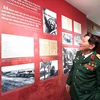 Trung tướng Phạm Tuân nhìn lại hình ảnh của chính mình trong trân chiến 50 năm trước. (Ảnh: Minh Thu/Vietnam+)