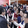 Các phóng viên tác nghiệp tại Đại hội XIII của Đảng tại Trung tâm Hội nghị Quốc gia (Hà Nội). (Ảnh: TTXVN)