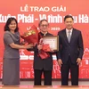 Bà Nguyễn Thị Sự, Phó Tổng Giám đốc Thông tấn xã Việt Nam (trái) trao Giải thưởng Lớn cho đạo diễn Đặng Nhật Minh. (Ảnh: Hòa Nguyễn/Vietnam+)