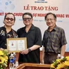 Nghệ sỹ Trần Mạnh Tuấn (trái) nhận Kỷ niệm chương "Vì sự nghiệp âm nhạc" của Hội Nhạc sỹ Việt Nam. (Ảnh: NVCC)