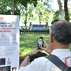 Khách tham quan quét mã QR để trải nghiệm bức tranh 3D về Chiến thắng Điện Biên Phủ. (Ảnh: CTV/Vietnam+)