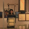 Phan Tuấn Ngọc chụp cùng các tác phẩm ''Dòng thời gian'' tại triển lãm. (Ảnh: Minh Anh/Vietnam+)