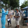 Người dân ngồi xếp hàng để được tiêm vaccine Vero Cell tại điểm tiêm Trung tâm văn hóa phường Phú Lợi, thành phố Thủ Dầu Một, tỉnh Bình Dương. (Ảnh: Chí Tưởng/TTXVN)