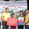 Hai mẹ con anh Nguyễn Minh Hùng tại thôn Văn Trị nhận hộ trợ từ Báo VietnamPlus và Samsung. (Ảnh: Minh Sơn/Vietnam+)