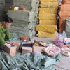 Lực lượng chức năng đang kiểm tra số hàng hóa gồm: ô mai và hoa quả khô, thu giữ được tại khu vực chợ Ninh Hiệp (Ảnh: Đức Duy/Vietnam+)