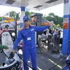 Nhân viên Petrolimex đang bán xăng cho khách hàng (Ảnh: TTXVN)