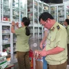Lực lượng quản lý thị trường Hà Nội đang kiểm tra thuốc và thực phẩm chức năng (Ảnh: Đức Duy/Vietnam+)