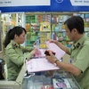 Lực lượng quản lý thị trường Hà Nội đang kiểm tra các cơ sở kinh doanh tân dược tại Trung tâm thuốc Hapu (Ảnh: Đức Duy/Vietnam+)