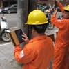 Nhân viên Tổng Công ty Điện lực Hà Nội đang ghi chỉ số công tơ của khách hàng (Ảnh: Đức Duy/Vietnam+)