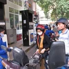 Nhân viên Petrolimex đang bán xăng cho khách hàng. (Ảnh: Đức Duy/Vietnam+)