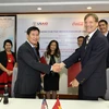 Ông Michael Greene, Giám đốc USAID Việt Nam, và Giám đốc chuỗi cung ứng Coca-Cola Việt Nam, ký biên bản ghi nhớ tại văn phòng của USAID Việt Nam. 