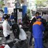 Nhân viên Petrolimex đang bán xăng cho khách hàng. (Ảnh: Đức Duy/Vietnam+)