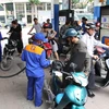 Nhân viên Petrolimex đang bán xăng cho khách hàng. (Ảnh: Đức Duy/Vietnam+)