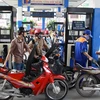 Nhân viên Petrolimex đang bán xăng cho khách hàng. (Ảnh: Đức Duy/Vietnam+)