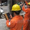 Nhân viên ngành điện đang chốt chỉ số công tơ của khách hàng. (Ảnh:Xuân Quảng/Vietnam+)