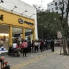 Một điểm bán hàng của Dệt Kim Đông Xuân đông kín người đứng xếp hàng chờ mua khẩu trang. (Ảnh: Đức Duy/Vietnam+)